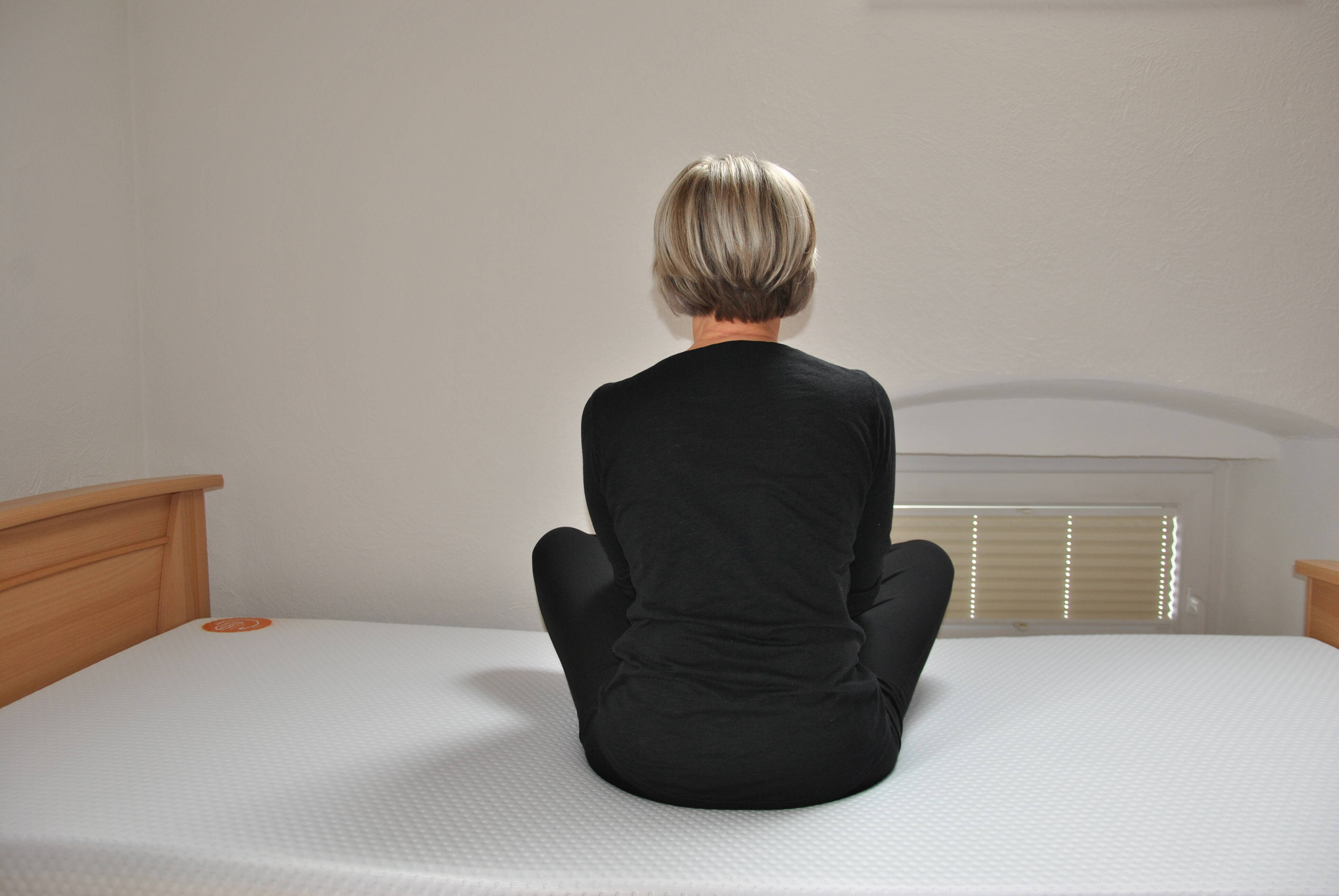 Frau sitzt auf Emma 25 Matratze Flip